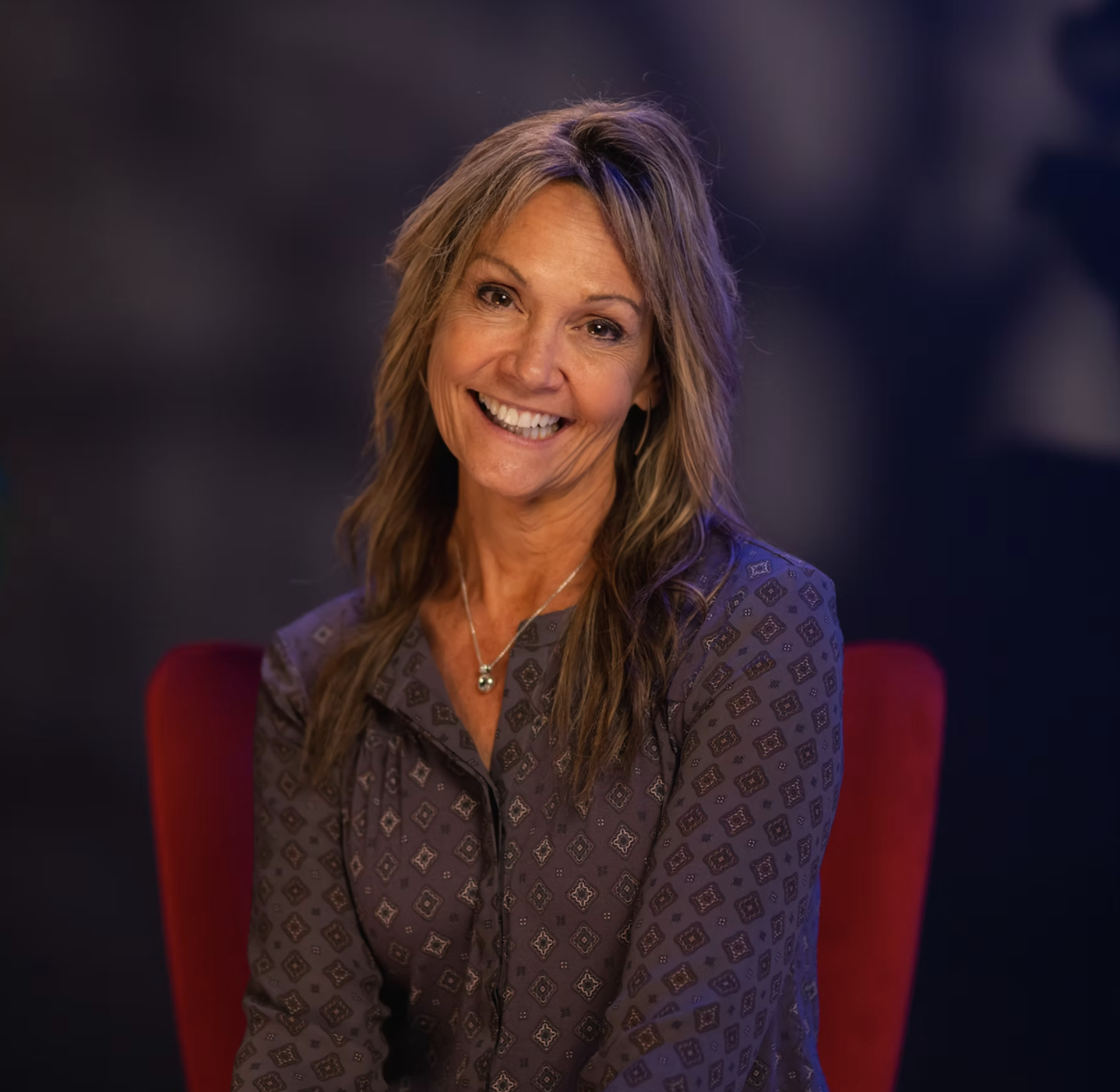 headshot of dr. Sandra Adams sitting in a red chair